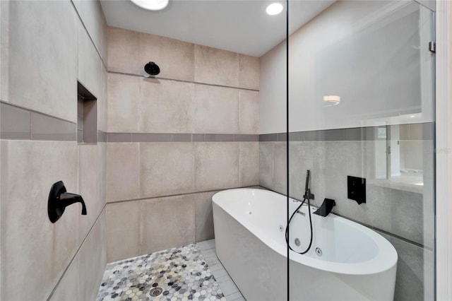 bathroom featuring tile patterned floors, plus walk in shower, and tile walls