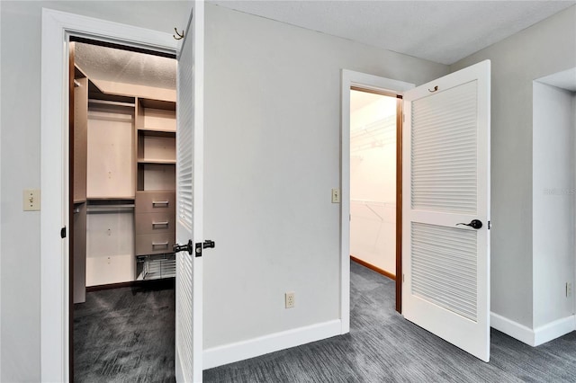 unfurnished bedroom featuring dark colored carpet and a closet