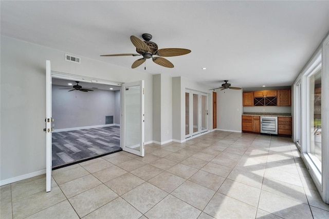 unfurnished living room featuring light tile patterned floors and wine cooler