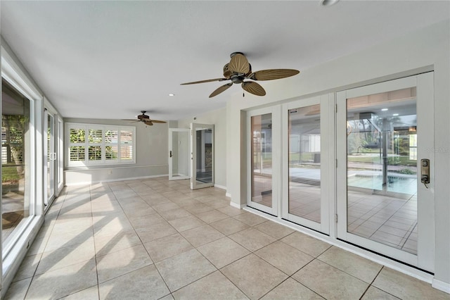 unfurnished sunroom with ceiling fan