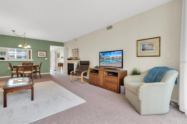 carpeted living room with an inviting chandelier