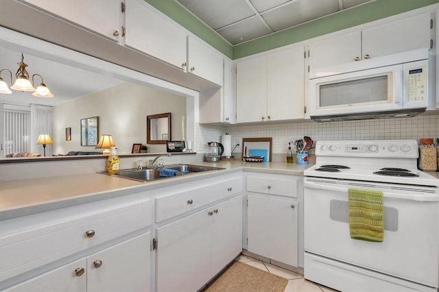 kitchen with backsplash, white appliances, and white cabinets