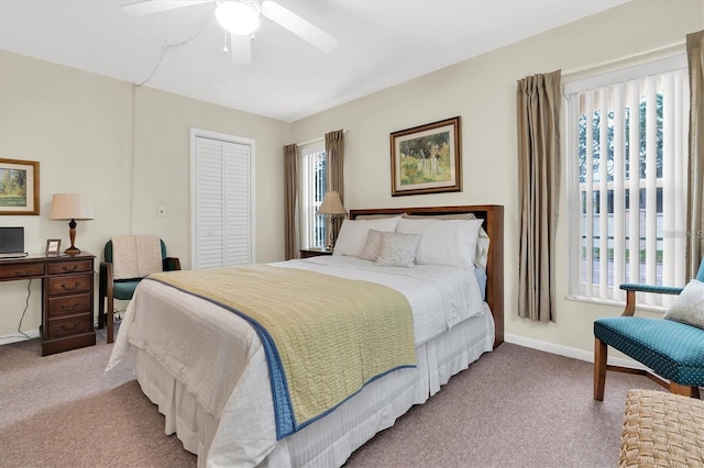 bedroom featuring ceiling fan, light colored carpet, a closet, and multiple windows