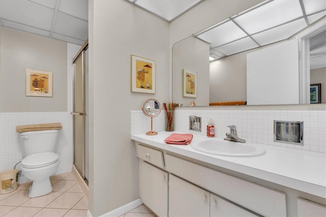 bathroom featuring a paneled ceiling, tile patterned flooring, vanity, an enclosed shower, and toilet