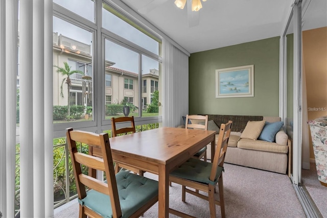 dining space with a wealth of natural light, light colored carpet, and ceiling fan