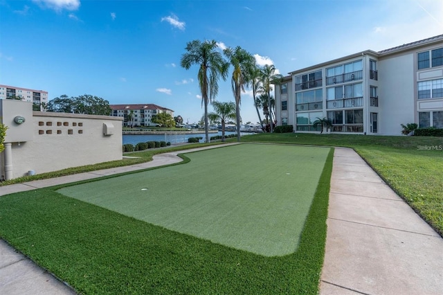 view of home's community with a water view and a lawn