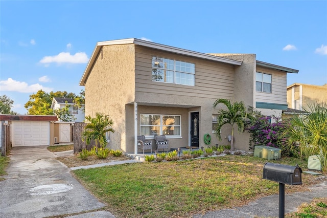 view of front of home with a garage, a front lawn, and an outdoor structure