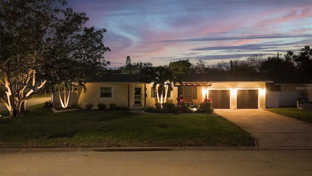 single story home with a garage and a yard