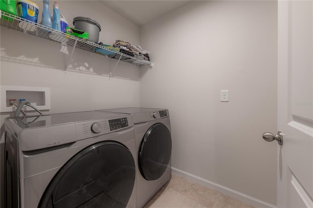 laundry area featuring washer and clothes dryer and light tile patterned floors