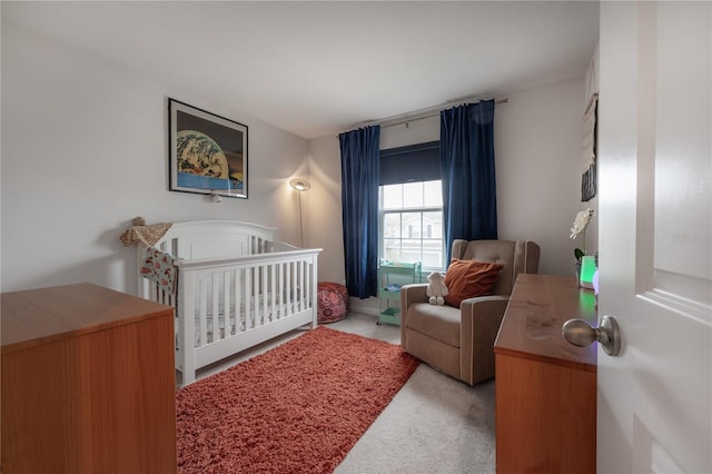 bedroom featuring a crib and light colored carpet