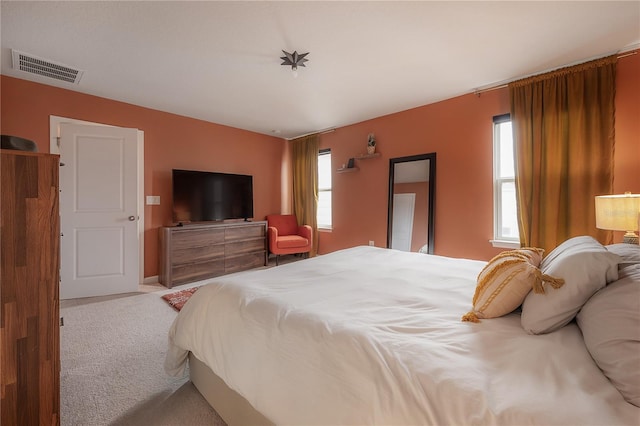 bedroom with multiple windows and light colored carpet