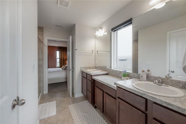 bathroom featuring tile patterned floors, plenty of natural light, a shower with shower door, and vanity