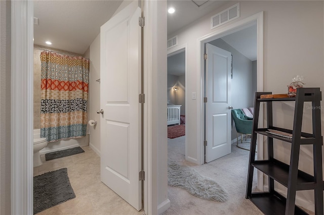 bathroom featuring shower / bath combo and toilet