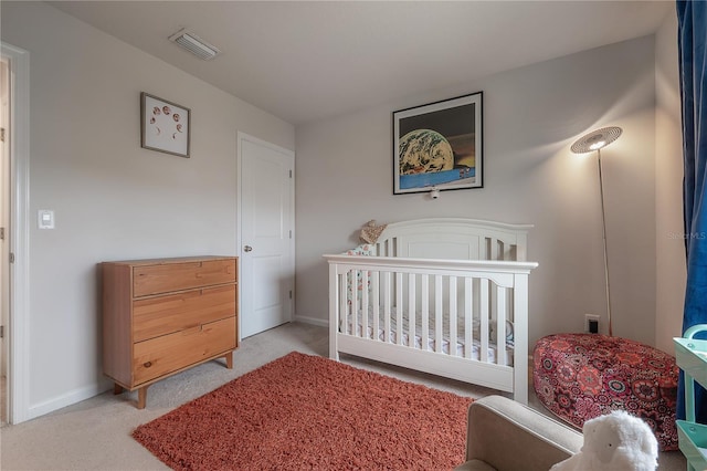 bedroom featuring light carpet and a crib