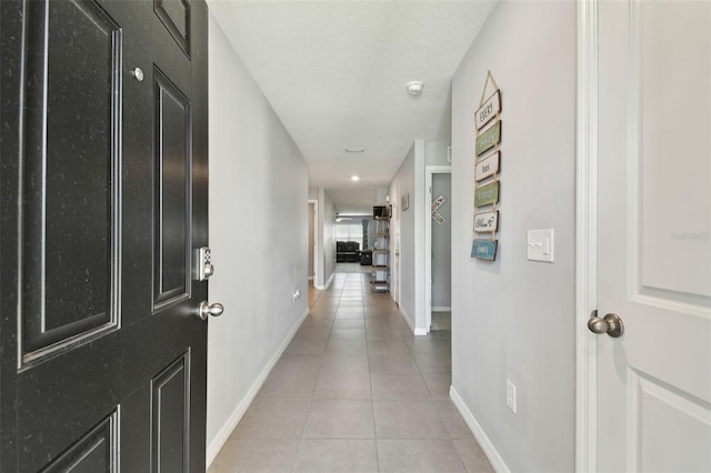 hallway with light tile patterned flooring and a textured ceiling