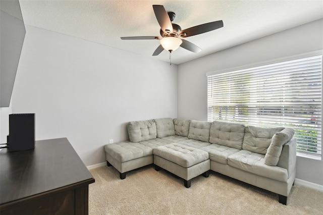 living room with light carpet, a textured ceiling, and ceiling fan