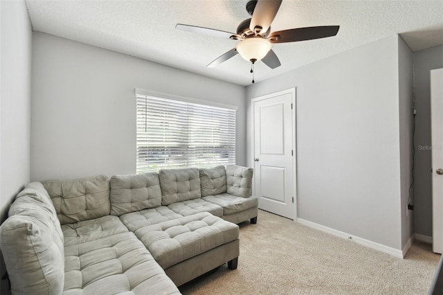 living room with a textured ceiling, ceiling fan, and light carpet