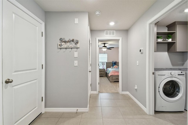 laundry area with cabinets, washer / dryer, light tile patterned floors, and ceiling fan