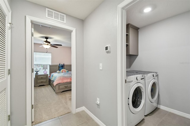 laundry room featuring washing machine and dryer, ceiling fan, light tile patterned flooring, and cabinets