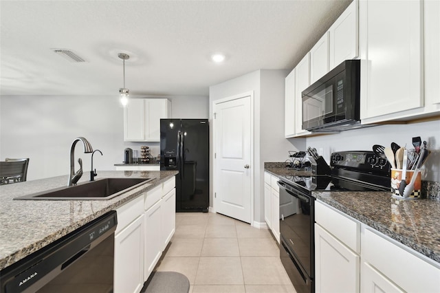 kitchen with dark stone counters, sink, white cabinets, and black appliances