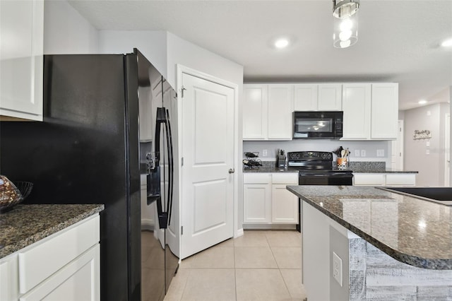 kitchen featuring light tile patterned flooring, dark stone countertops, white cabinets, and black appliances