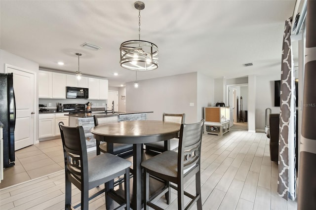 dining room featuring sink and an inviting chandelier