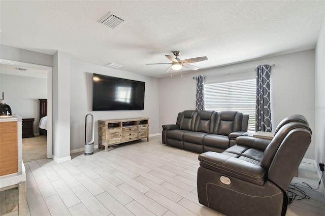 living room featuring a textured ceiling and ceiling fan