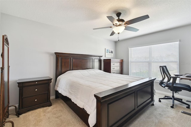 carpeted bedroom with ceiling fan and a textured ceiling