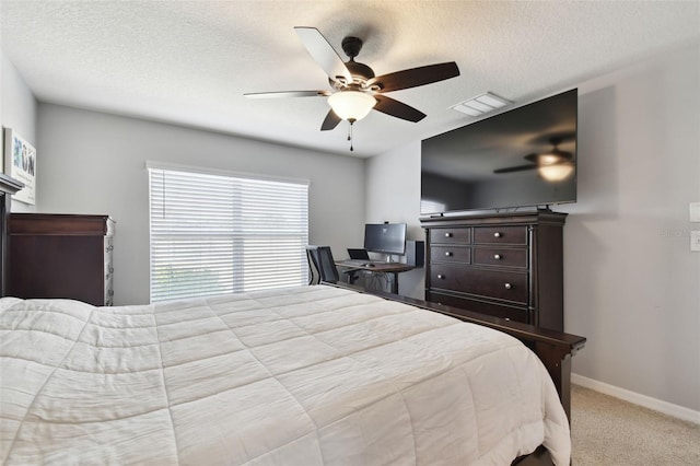 bedroom featuring ceiling fan, light colored carpet, and a textured ceiling