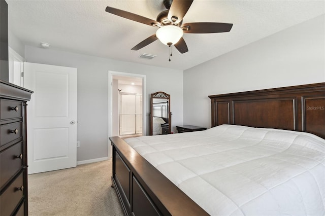 bedroom featuring light colored carpet, ceiling fan, and ensuite bathroom