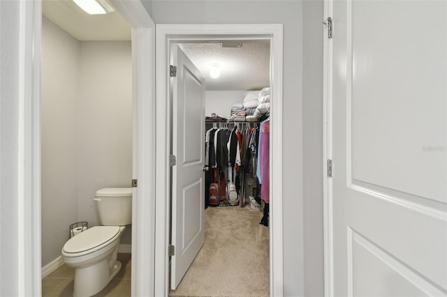 bathroom featuring a textured ceiling and toilet