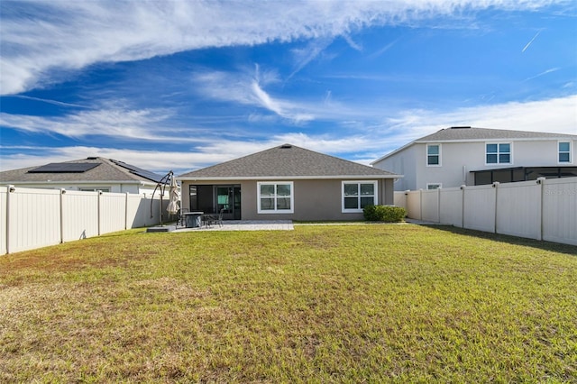 back of property with a lawn and a patio