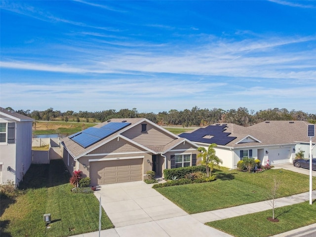 ranch-style house with solar panels, a garage, and a front lawn