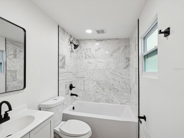 full bathroom with tiled shower / bath combo, vanity, and toilet