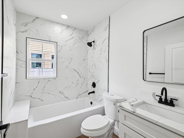 full bathroom featuring vanity, tiled shower / bath, and toilet