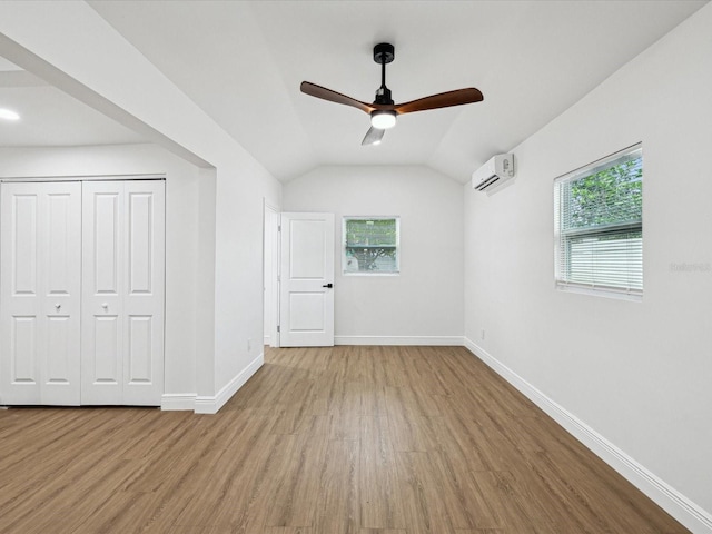 bonus room with lofted ceiling, a wealth of natural light, light hardwood / wood-style flooring, and an AC wall unit