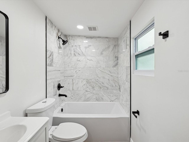 full bathroom with tiled shower / bath, vanity, and toilet