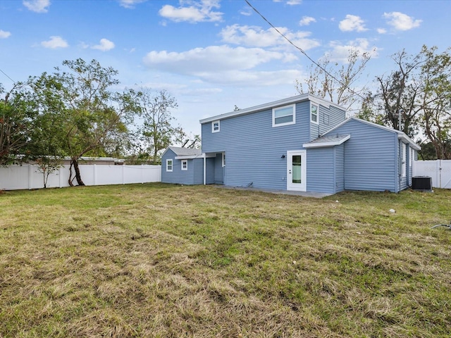 rear view of house featuring a yard and central air condition unit