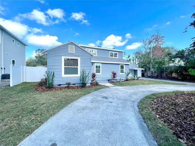 view of front of house with central AC and a front yard