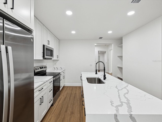 kitchen featuring stainless steel appliances, light stone countertops, sink, and white cabinets