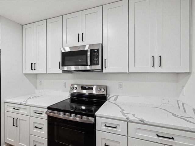 kitchen featuring white cabinetry, stainless steel appliances, and light stone counters