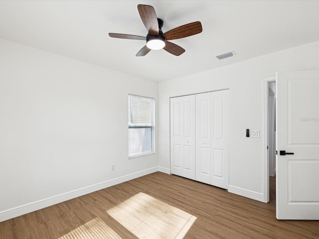 unfurnished bedroom with hardwood / wood-style floors, ceiling fan, and a closet