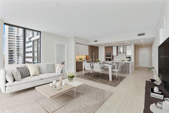 tiled living room featuring floor to ceiling windows and sink