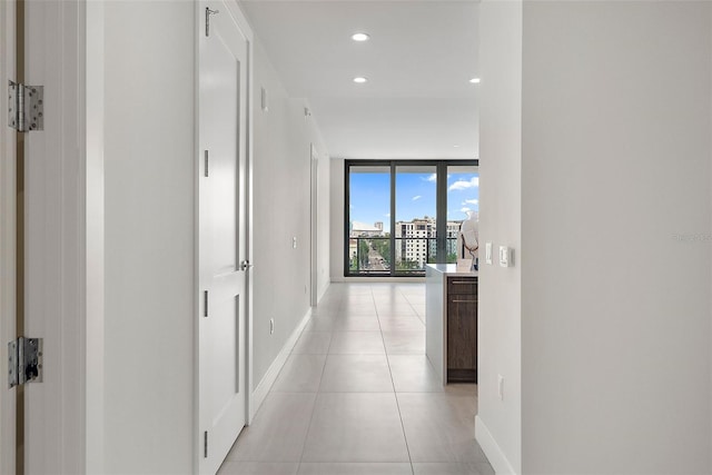 corridor featuring floor to ceiling windows and light tile patterned floors