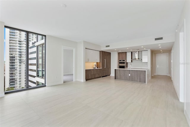 unfurnished living room with floor to ceiling windows and sink