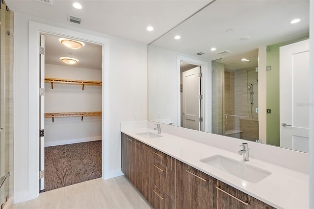 bathroom with vanity and a shower with door