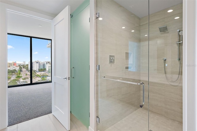 bathroom featuring a shower with shower door and a wall of windows