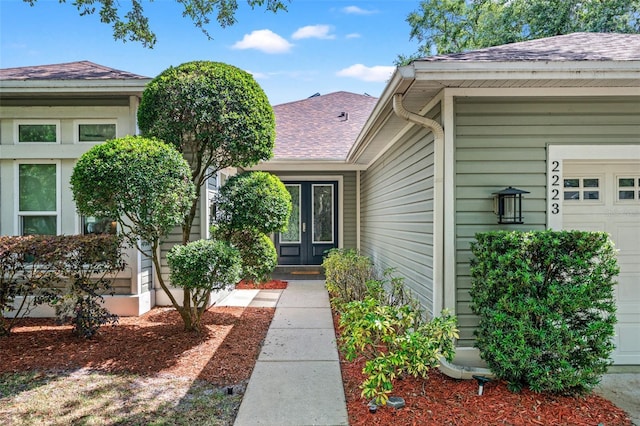 entrance to property featuring a garage and french doors