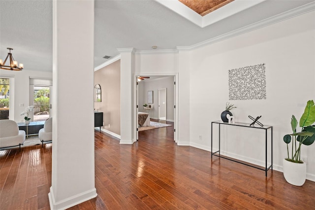 foyer entrance featuring hardwood / wood-style floors, ceiling fan with notable chandelier, ornate columns, and crown molding