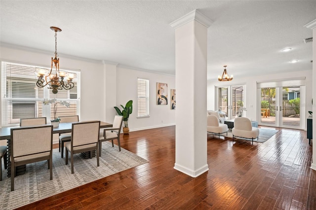 dining area with an inviting chandelier, crown molding, dark wood-type flooring, and french doors